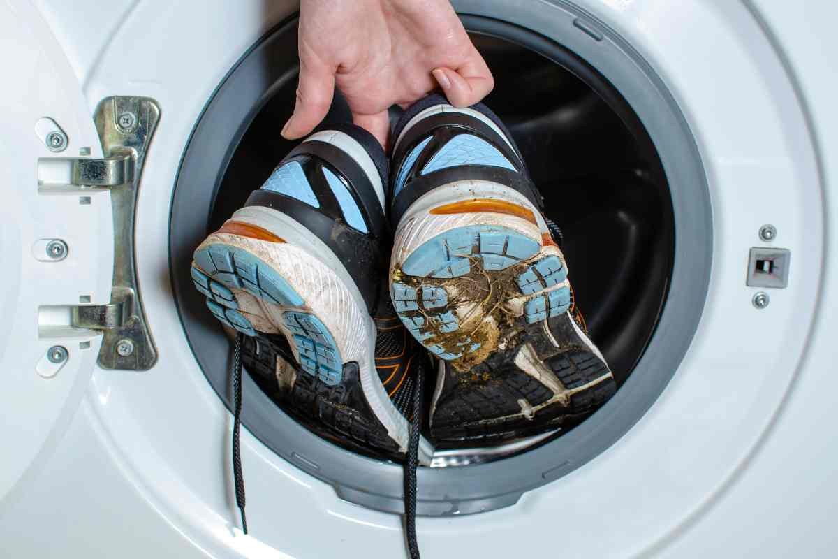 Mani mettono scarpe sporche in lavatrice