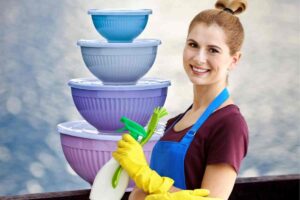 Donna con guanti da cucina e ciotole di plastica