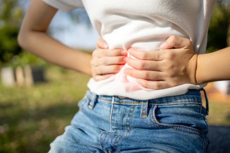 Ragazza che si tiene la pancia per il dolore