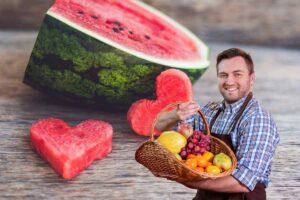 anguria con pezzi a forma di cuore e fruttivendolo con cesta di frutta in mano