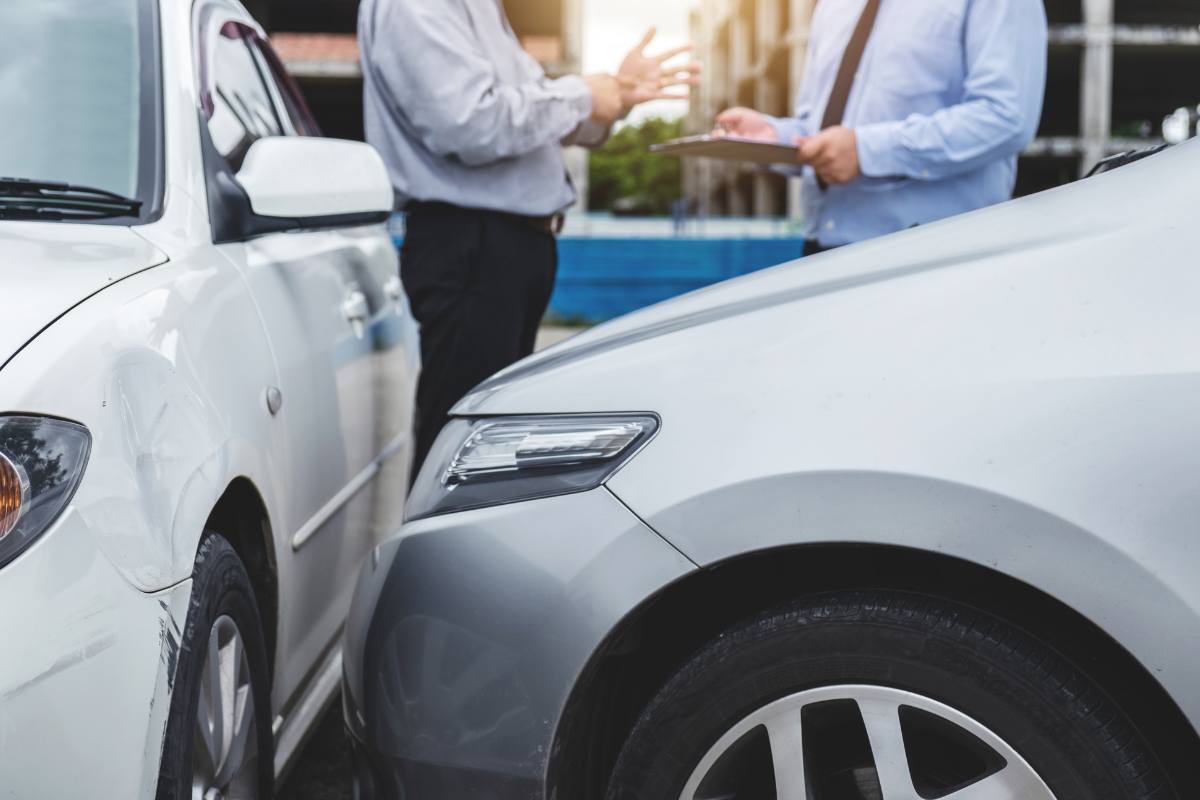 Due automobilisti che compilano la contestazione amichevole dopo un incidente 