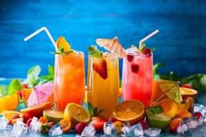 3 bicchieri con bevanda colorata, frutta, decorazioni