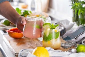 Bicchieri con cocktail colorati e foglie di erbe