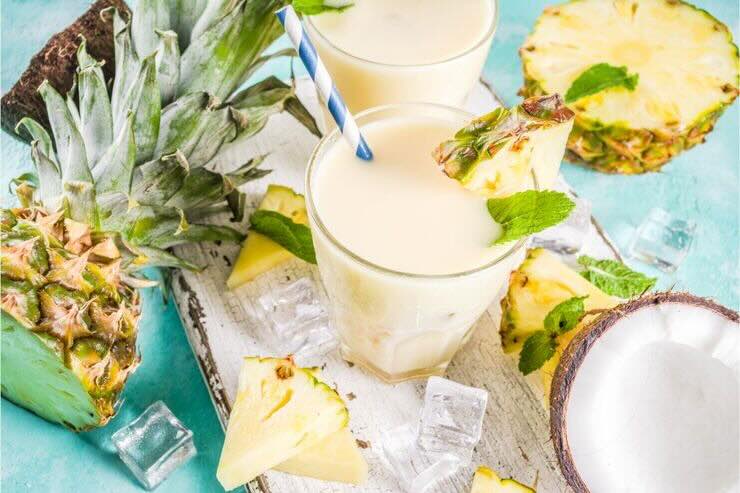Bicchiere con cocktail cremoso, ananas, cocco