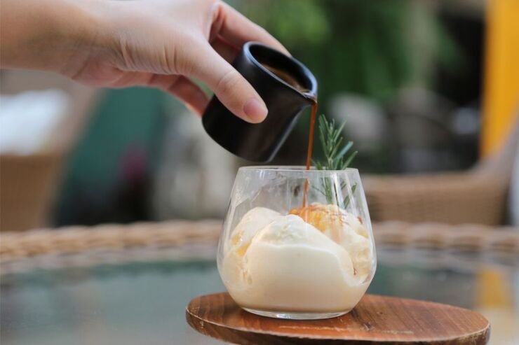 Versare caffè in un bicchiere con panna