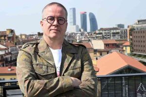 Ernst Knam in piedi a braccia conserte