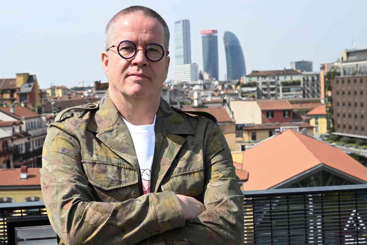 Ernst Knam in piedi a braccia conserte