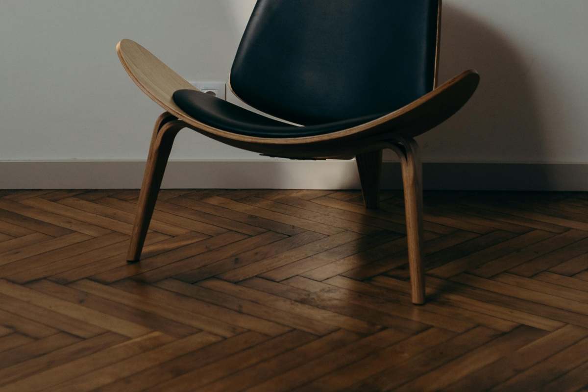 Una sedia design su un parquet scuro