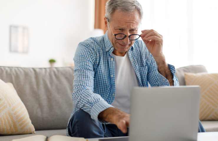 uomo sorpreso legge su pc